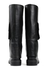 Czarne skórzane buty za kolano o gładkiej fakturze, płaskich podeszwach i bocznych akcentach. Tył ma szwy i lekki obcas.