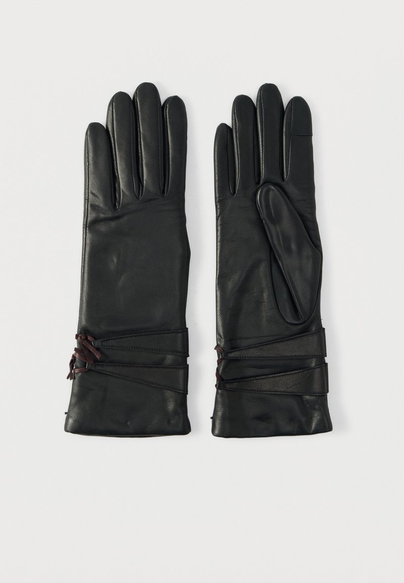 Luvas de couro preto com três dedos alongados, textura suave e laços decorativos castanhos no pulso para ajuste.