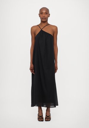 Svart maxikjole med halterneck, kryssede stropper og flytende gjennomsiktig stoff. Har et minimalistisk design og lagdelt tekstur.