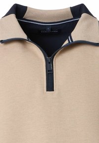 Beżowy pulower na zamek z granatowymi akcentami i prążkowaną teksturą. Posiada kontrastowy kołnierz i zamek błyskawiczny do zapięcia. Widoczna etykieta marki.