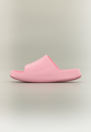 Sandalo slip-on rosa con suola testurizzata e sottile logo Nike a swoosh in rilievo sul lato, mostrato di profilo su sfondo neutro.
