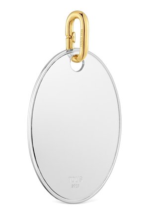 Colgante ovalado de plata con un pequeño agujero redondo en la parte superior, unido a un cierre de mosquetón dorado grabado con "TOUS S925."