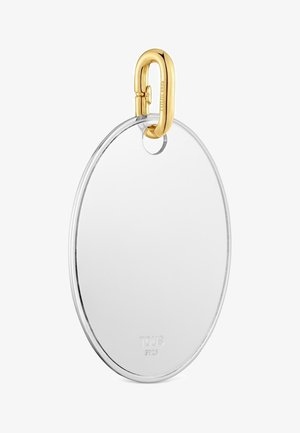 Colgante ovalado de plata con un pequeño agujero redondo en la parte superior, unido a un cierre de mosquetón dorado grabado con "TOUS S925."