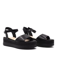 Sandales à plateforme en cuir noir avec orteils ouverts, brides de cheville et semelle intermédiaire texturée ressemblant à du jute pour plus de hauteur et d'adhérence.