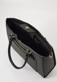 Black leather handbag with a textured finish, gold-tone hardware, zippered pocket, and two handles. Open top reveals a spacious interior.