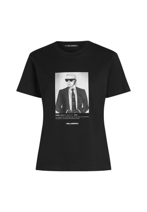 T-shirt noir avec une photo en noir et blanc d’un homme en lunettes de soleil et costume, texte définissant "I-kon" et "KARL LAGERFELD" en dessous.