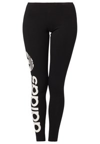 Černé legíny z elastické látky, s bílým logem a grafikou na levé straně. Přiléhavý střih, standardní výška pasu.