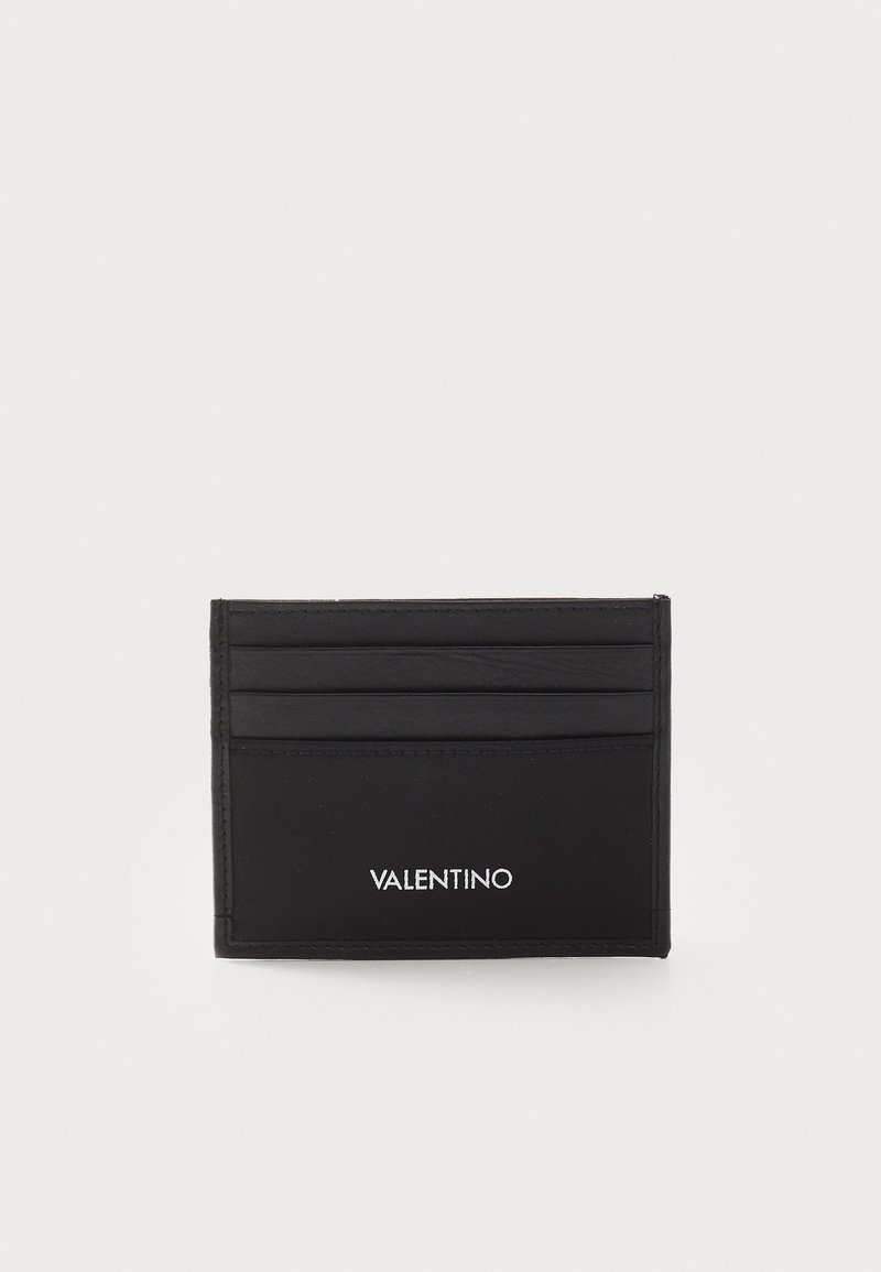 Porte-cartes noir en cuir texturé avec plusieurs emplacements pour cartes et un petit logo embossé sur le devant. Design minimaliste.