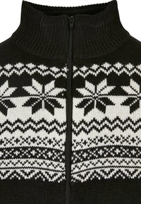 Suéter de punto negro con cuello alto y cremallera frontal, que presenta un patrón repetitivo de copos de nieve blancos y bandas texturizadas en contraste.