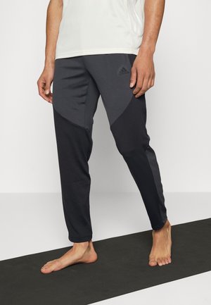 Zwarte sportbroeken met een taps toelopende pasvorm kenmerken zich door een combinatie van donkergrijze en zwarte panelen. Gemaakt van lichtgewicht, flexibel materiaal.