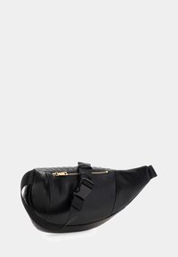 Borsa in pelle nera a vita con motivo trapuntato, zip dorata e tracolla regolabile con fibbia a rilascio laterale su sfondo semplice.
