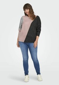 Färgglad tröja med blockfärger i rosa, grått och svart. Har en avslappnad passform, långa ärmar och en mjuk textur. Kombinationen med blå jeans.