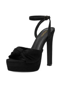 Černé vysoké platformové sandály na podpatku s semišovou texturou, otevřenou špičkou, uzlem v přední části a nastavitelným páskem kolem kotníku. Design s jehlovým podpatkem.