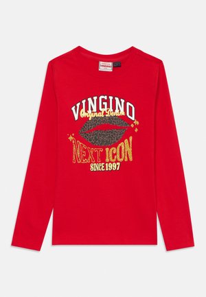 Chemise rouge à manches longues avec « VINGINO », lèvres imprimées léopard et texte doré indiquant « Original Denim Next Icon Since 1997 » sur le devant.