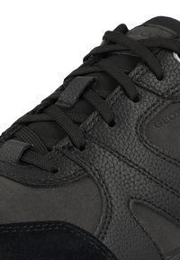 Czarne buty sportowe z teksturowaną skórzaną cholewką, z siateczkowymi detalami i okrągłymi sznurówkami. Obecne są również akcenty z zamszu oraz wzmocnione oczka.