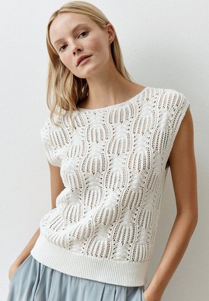 Haut en tricot blanc avec un motif ouvert texturé, encolure bateau et manches courtes. Finition avec un ourlet en côte. Stylé avec une jupe bleu clair.