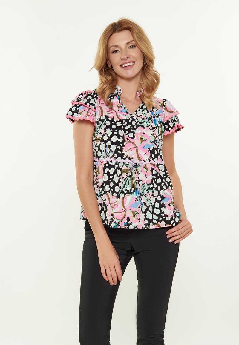 Blusa a maniche corte con scollatura a V, caratterizzata da un motivo floreale in rosa e blu su uno sfondo nero. Maniche con volant e tessuto morbido.