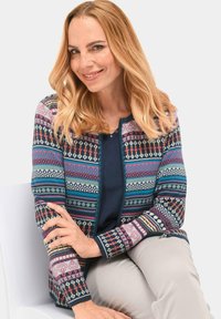 Gebreide cardigan met een veelkleurig geometrisch patroon, met blauwe, roze en grijze accenten. Ronde neklijn en geribde manchetten.