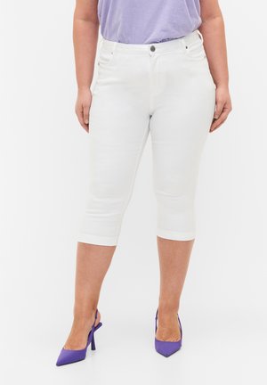Jeans blancos recortados con una silueta ajustada, que presentan un diseño de cinco bolsillos y costuras en contraste. Combinados con zapatos de tacón altos morados.