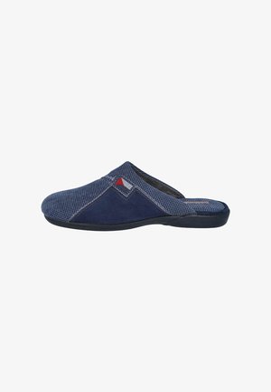 Zapatos navy tipo slip-on hechos de una tela texturada con un panel de gamuza suave, que presentan un pequeño acento rojo y una suela de goma flexible.