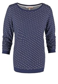 Granatowy sweter z długim rękawem w białe kropki, okrągły dekolt oraz ściągacze przy rękawach i na dole.