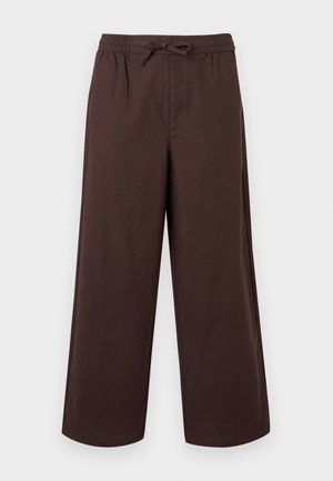 Hnedé široké nohavice s elastickým pásom a predným šnurovaním, vyrobené z hladkej látky.