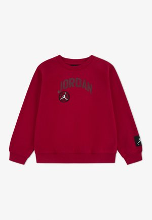 Rdeč dolg rokav s potiskom "JORDAN" in črno-belo značko z logotipom Jumpman na sredini ter črno etiketo z logotipom na rokavu.