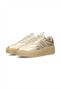 Sneaker metallizzati oro con una texture liscia, design con lacci e suola in gomma beige spessa. Presentano strisce laterali e un colletto imbottito.