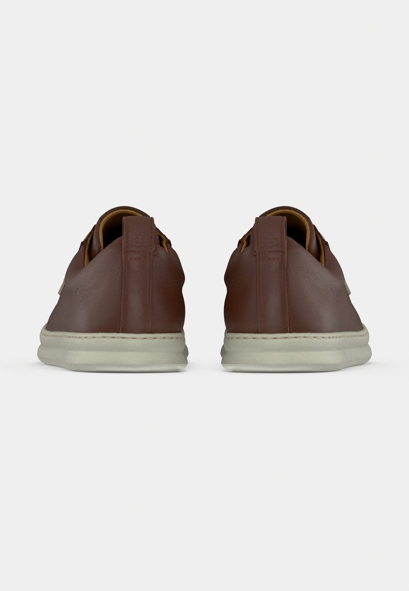 Brown leather shoes with a smooth texture, minimalistic design, and beige rubber soles. Features a contrasting brown tongue and back tab.