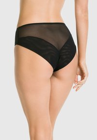 Czarnie wysokie majtki wykonane z gładkiego materiału, z przezroczystymi panelami z siateczki z tyłu, o zakrzywionym designie zapewniającym dopasowany kształt.