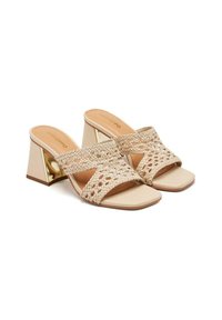 Sandalias deslizantes tejidas de color beige con puntera cuadrada y un tacón bloque de altura media, con un acento dorado en el tacón. Textura suave en la plantilla.