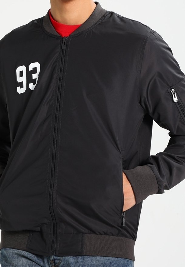 Schwarze Bomberjacke mit weißer "93" auf der Brust, mit durchgehendem Reißverschluss, gerippten Bündchen und Seitentaschen. Glattes, leichtes Material.
