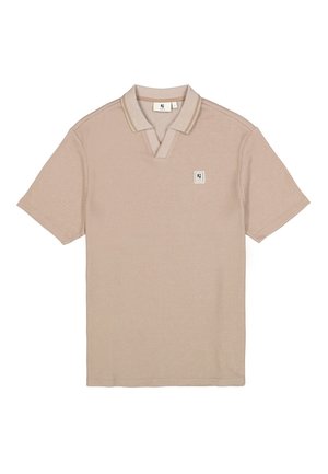 Camiseta polo en beige claro con tejido texturizado, mangas cortas, cuello puntiagudo y un pequeño parche con logo en el pecho.
