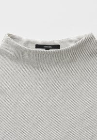 Gestreiftes grau-weißes T-Shirt mit rundem Halsausschnitt und einem schwarzen Etikett mit der Aufschrift "irgendwann". Weiches Material mit feinen diagonalen Linien.