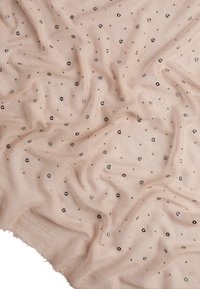 Nude tkanina z rozrzuconymi metalicznymi okrągłymi akcentami. Miękka tekstura o zwiewnym wzorze, prezentująca pognieciony wygląd.