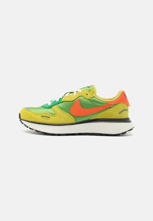 Tenisky Nike s vrchním materiálem z zelené a žluté jemné kůže, s oranžovými akcenty, bílými tkaničkami a černou gumovou podrážkou. Klasický běžecký design.