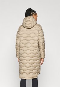 Beige gewatteerde jas met een doorgestikt, golfachtig textuur en een capuchon, die tot halverwege de bovenbenen reikt, met lange mouwen en een rechte zoom.