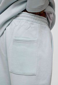 Lichtblauwe sweats met een elastische tailleband en een patchzak aan de zijkant, gemaakt van zachte, ademende stof.