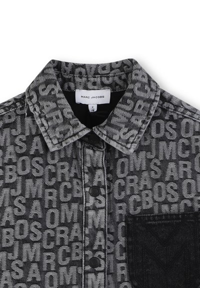 Zwarte denim jas met een textuurpatroon van witte letters en symbolen. Inclusief een zwarte zak en zwarte knopen. Label: Marc Jacobs.