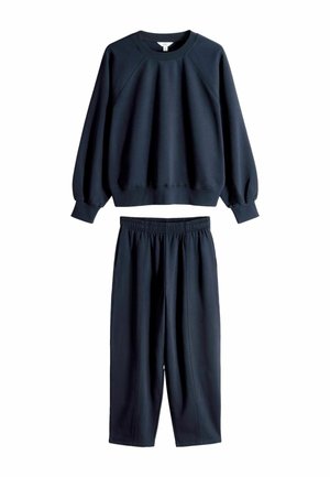 Marineblaue Sweatshirt mit Rundhalsausschnitt und Raglanärmel, kombiniert mit passenden lockeren Hosen mit elastischem Bund. Glatte Textur.