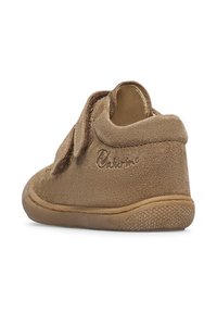 Scarpa marrone scamosciata con punta arrotondata, cinturino in Velcro e suola testurizzata per una buona aderenza. Nome del marchio impresso sul lato, design minimalista.