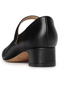 Scarpa in pelle nera con tacco basso a blocco e design aperto sul retro. Texture liscia, forma minimalista e sottili dettagli di cucitura.