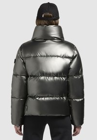 Giacca puffer metallica di colore grigio scuro, con colletto alto e design trapuntato. Realizzata in materiale liscio e lucido con polsini elastici.