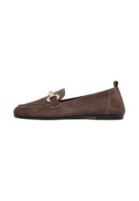 Mocassin plat en daim marron avec détail de boucle en ton or et semelle noire, vue de côté sur fond blanc.