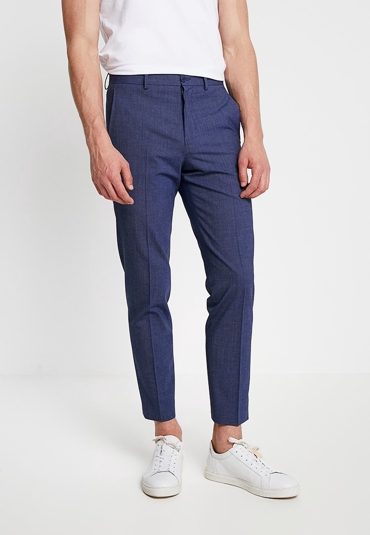 Marinblå skräddarsydda byxor med en texturerad tyg, slim fit, framfickor och en slät midja, i kombination med vita sneakers.