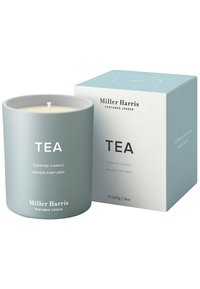 Duftkerze in einem hellblauen Keramikbehälter mit der Aufschrift "TEA", begleitet von einer hellblauen und weißen Schachtel, Größe 220g, im minimalistischen Design.