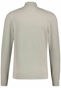 Pull léger en gris, avec un col montant, des manches longues, une texture côtelée et de subtils motifs horizontaux sur les manches.