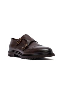 Donkerbruin leren dubbele monkstrap-schoen met gouden gespen en een dikke, ribbelige zool op een witte achtergrond.
