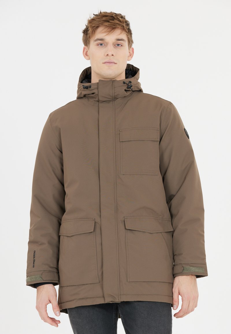 Brun isolerad jacka med dragkedja framtill, justerbar huva och fyra fickor; har ett strukturerat tyg och kontrasterande gröna detaljer.