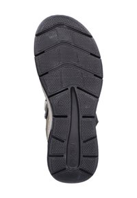 Semelle de chaussure en caoutchouc noir avec un motif texturé, comprenant des rainures en zigzag pour une meilleure adhérence et un logo de marque visible.